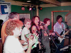 Click for enlarged view. Partiers join the band on stage.
